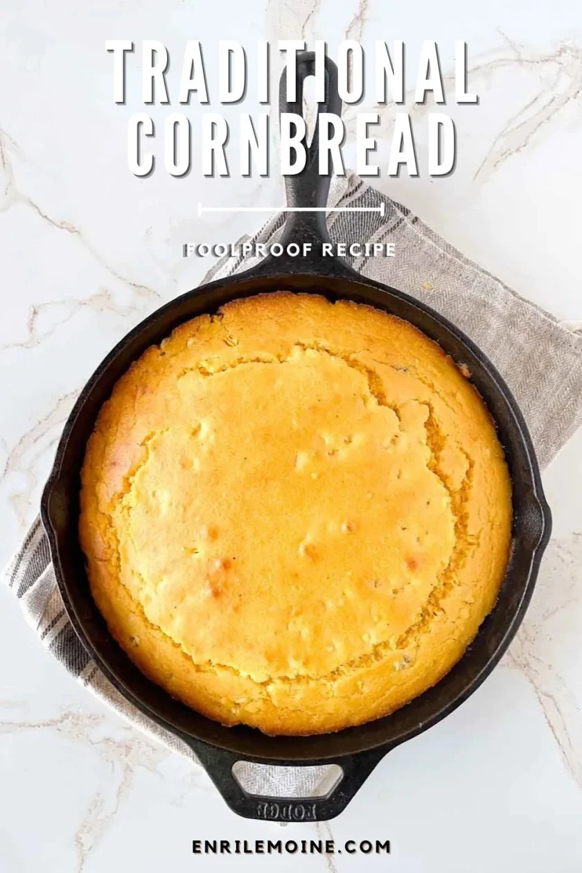 Golden cornbread baked in a cast iron skillet, this easy cornbread rests on a gray cloth over a marble surface.