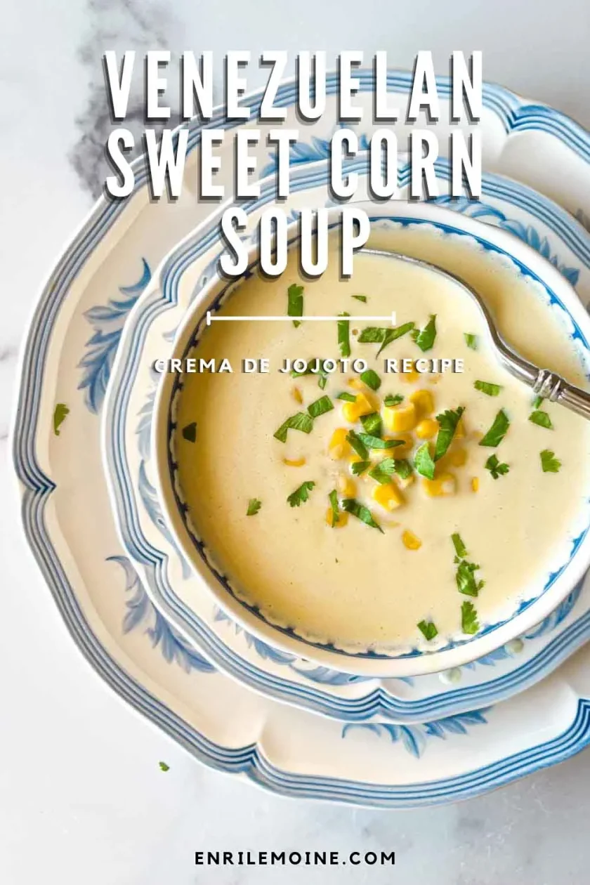 Bowl of creamy crema de jojoto venezolana, a classic sweet corn soup, garnished with corn and herbs on blue and white dishes.