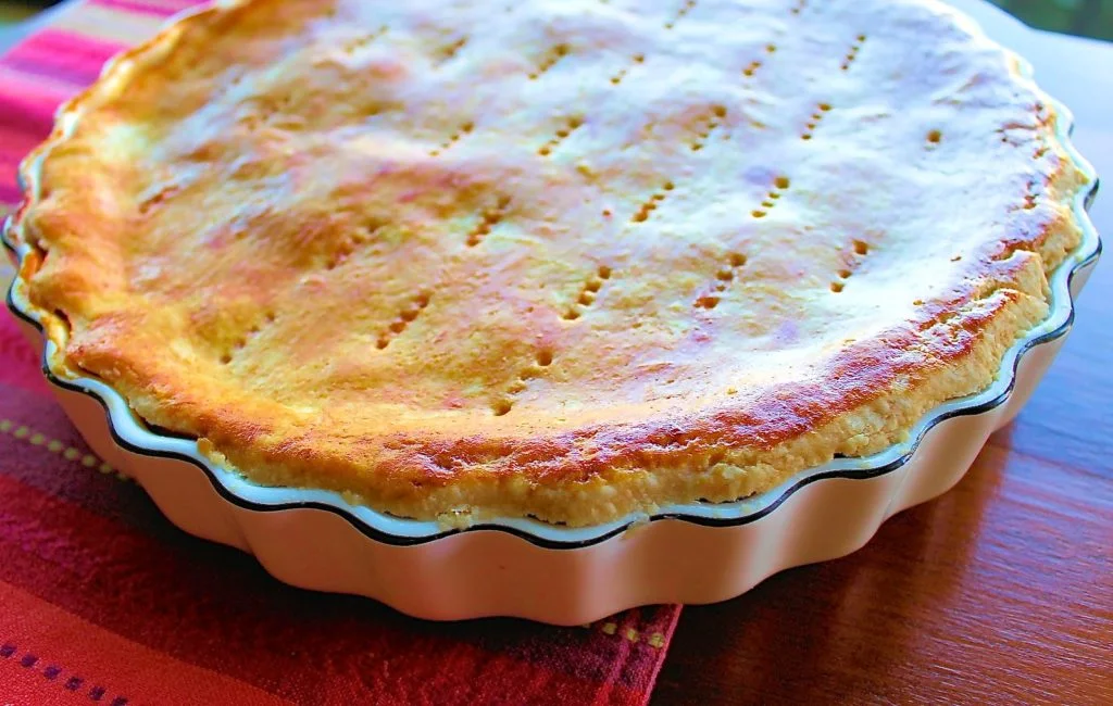 Polvorosa de atún recien salida del horno en un refractario de cer'amica sobre una superficie de madera.