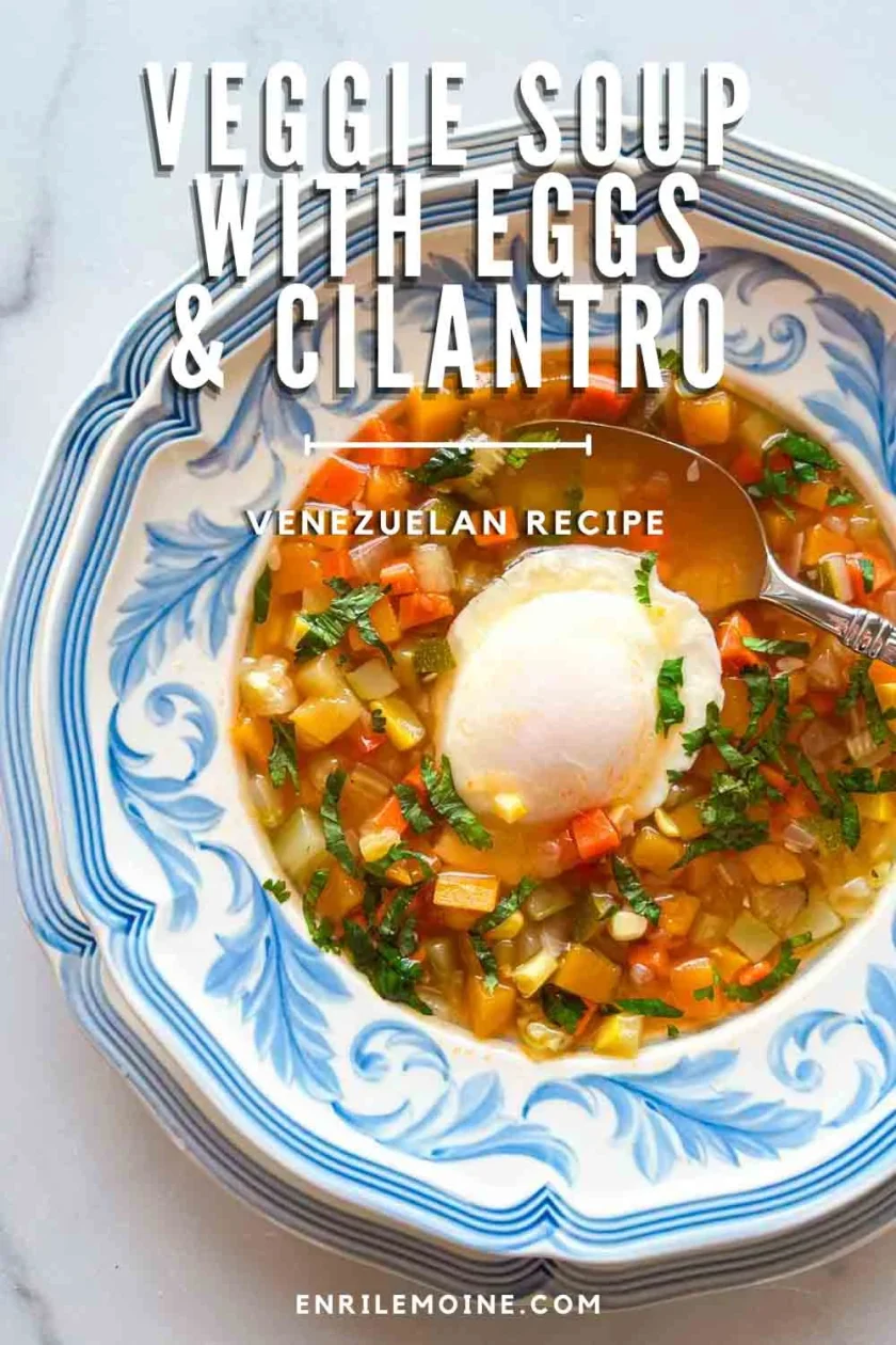 Bowl of veggie soup with a poached egg and cilantro, labeled as a Venezuelan recipe.