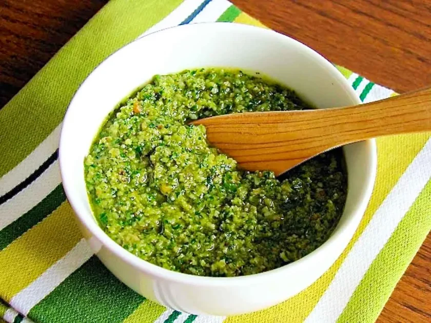 Un tazon blanco de pesto de rúcula y nueces