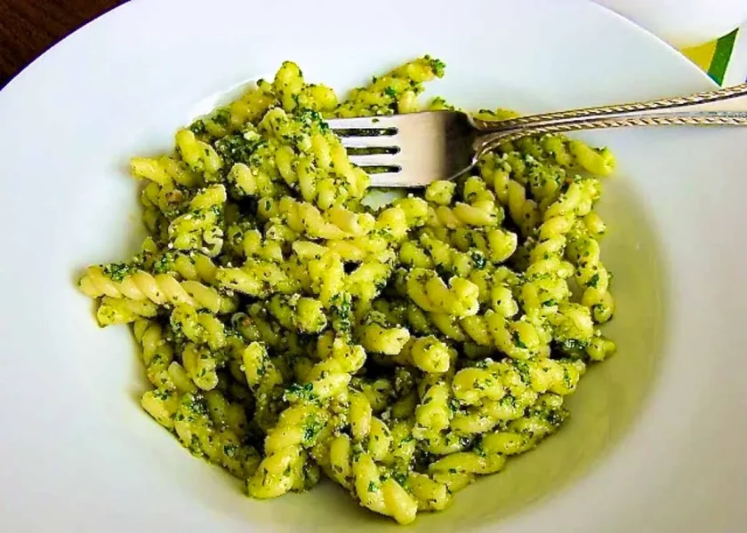 un plato de pasta al pesto de rúcula con nueces