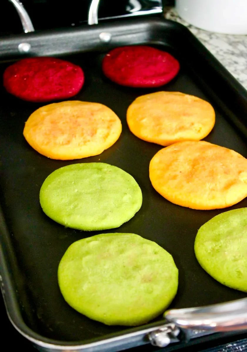 8 veggie-colored arepas on a double-sided griddle.