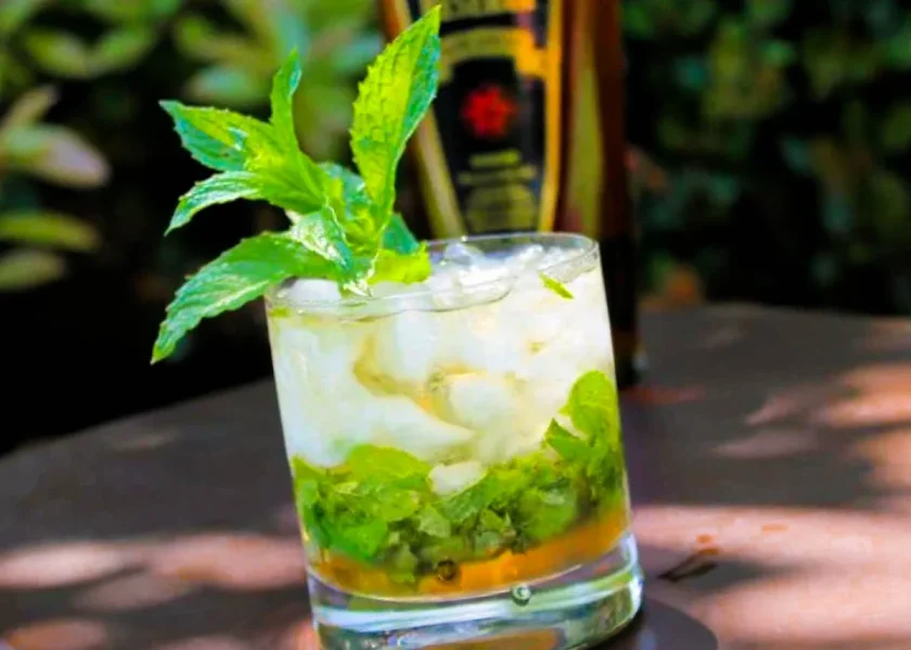 a rum mint julep with a Ron de Venezuela bottle in the back ground