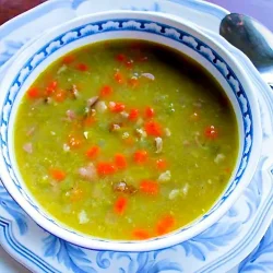 sopa de arvejas con jamón en un bol blanco con arabescos en azul.