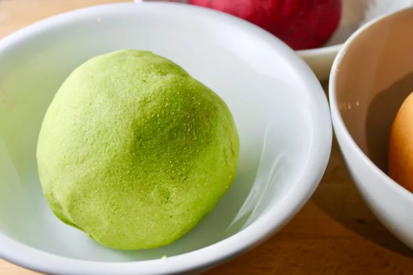  a ball of cilantro-colored arepa dough in a white bowl.