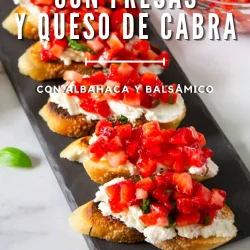 Crostini de fresas con queso de cabra, albahaca y glaseado balsámico, dispuestas en una bandeja rectangular negra. Texto en español que describe el plato.