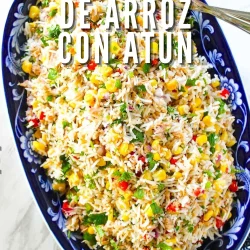 Plato ovalado azul relleno de ensalada de arroz mezclada con atún, maíz, pimientos rojos y hierbas. El texto de la imagen dice: "Ensalada de arroz con atún.