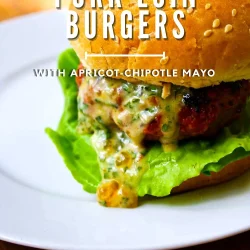 A grilled pork loin burger with lettuce and apricot-chipotle mayo on a sesame seed bun, served on a white plate. Text overlay describes the burger.