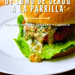 Primer plano de una hamburguesa de lomo de cerdo con lechuga y salsa en un plato blanco. Texto en español que describe hamburguesas de lomo de cerdo a la parrilla con mayonesa de melocotón y chipotle.
