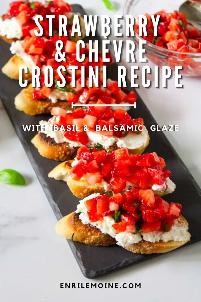 Sliced toasted bread topped with goat cheese, chopped strawberries, basil, and balsamic glaze, arranged on a black serving tray. Text reads: "Strawberry & Chevre Crostini Recipe.