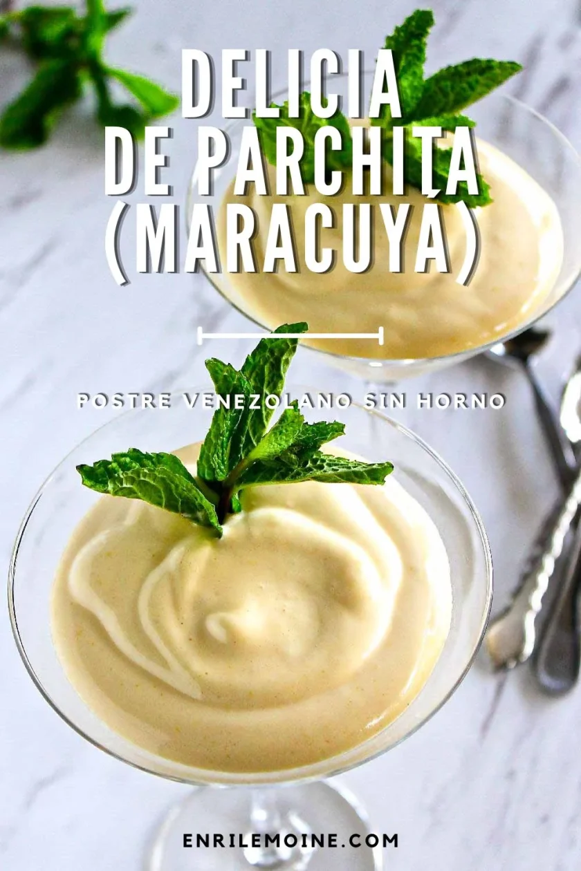 Dos copas de postre de cristal llenas de una cremosa mousse de maracuyá, adornadas con hojas de menta fresca, sobre una superficie de mármol con cucharas junto a ellas. Un texto superpuesto describe el postre.