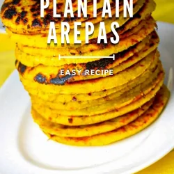 A stack of golden Venezuelan plantain arepas sits on a white plate, with text overlay reading "Venezuelan Plantain Arepas, Easy Recipe.
