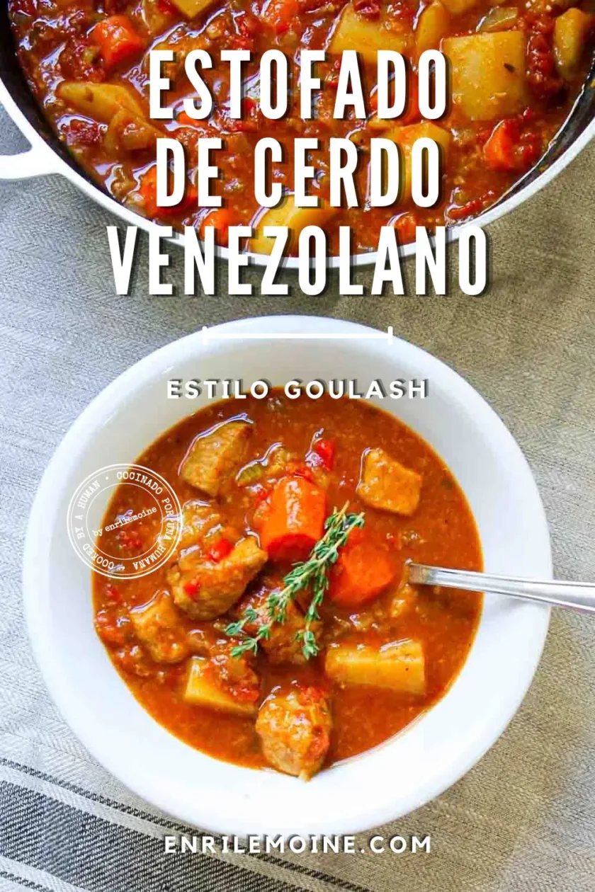 Un cuenco de estofado venezolano de cerdo con verduras y una ramita de tomillo, junto a una olla con el mismo estofado, sobre un mantel a rayas.